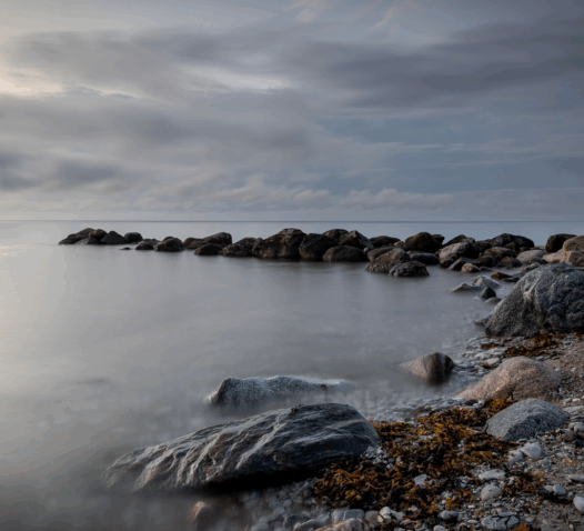 Klippor vid en havskust under en mulen himmel.